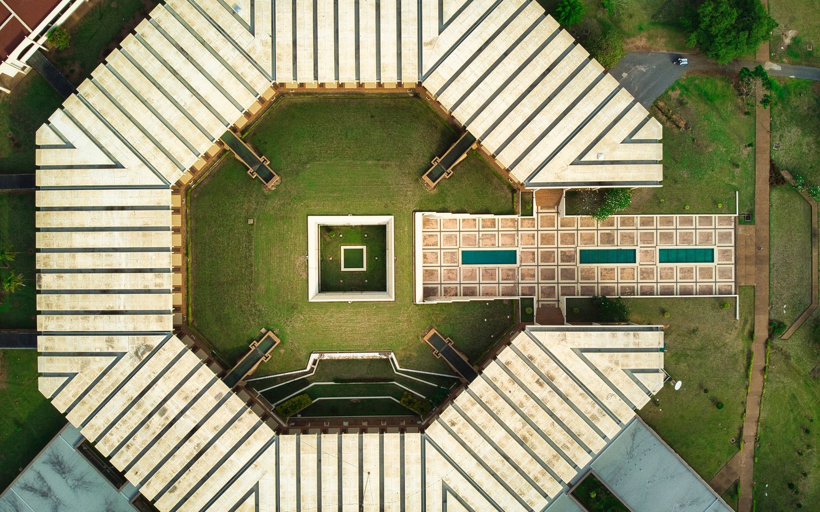 Aerial view of an octagonal building surrounding a courtyard with a reflecting pool and lawn